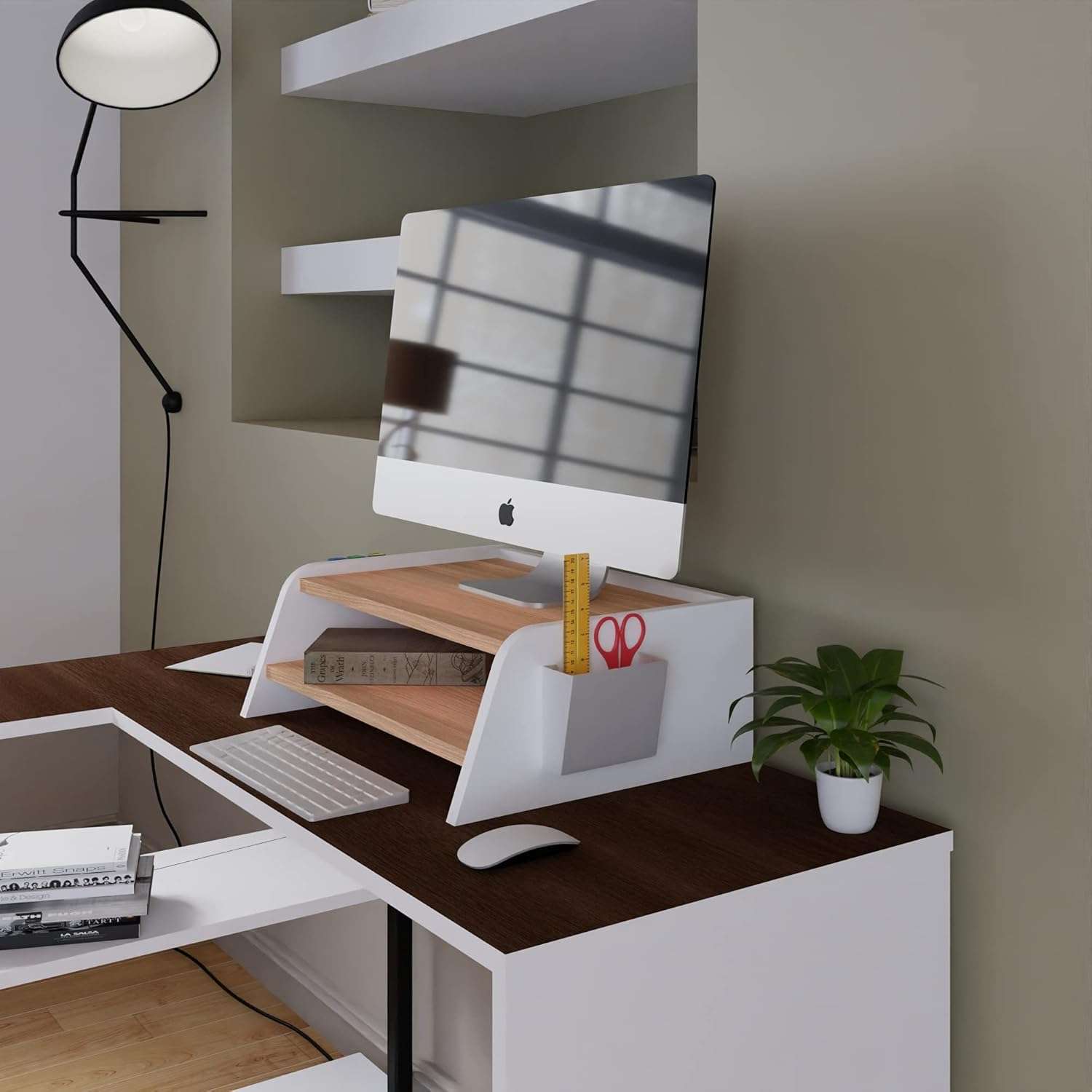 Butley Monitor Stand in white with wooden shelf, organizing office items on a brown desk with a computer and plant.