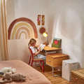 Daikin MC30Y air purifier in a cozy child's bedroom with a rainbow wall decal and wooden desk.