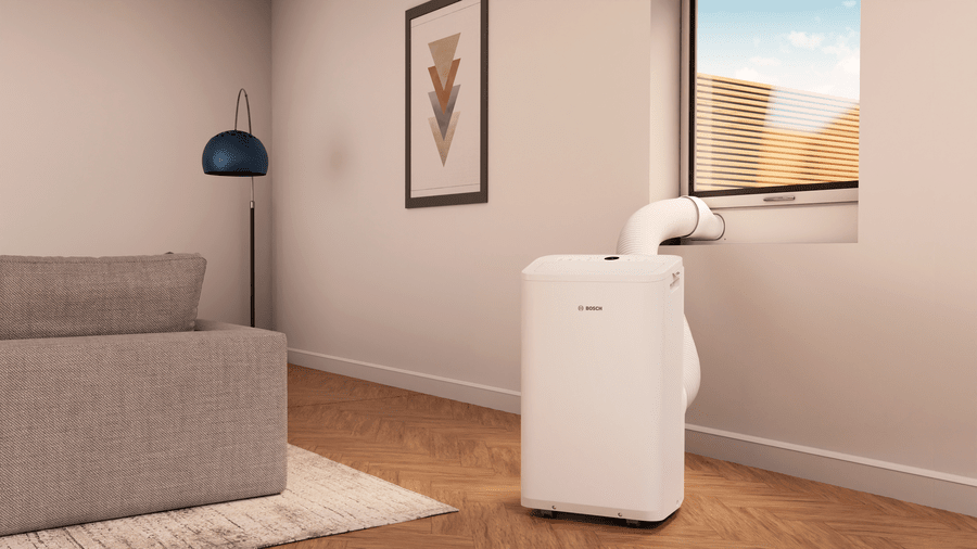 Bosch Cool 2000 mobile Klimaanlage with white compact design in modern living room next to window venting heat outside