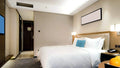 Modern hotel room with comfortable bed, beige walls, and Bosch Climate 5000iU D ducted air conditioning system providing quiet and efficient climate control.