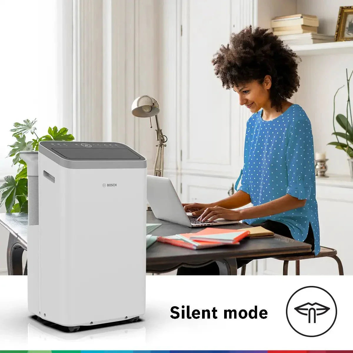 Bosch Cool 5000 mobile air conditioner in silent mode with compact design and remote control on wooden desk in modern home office