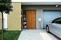 Bosch Power Charge 7000i smart home wallbox charger mounted on house exterior near electric car and garage door.