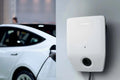 Bosch Power Charge 7000i smart electric vehicle wallbox charger installed on wall with car charging in background